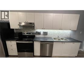 A kitchen with white cabinets and a black countertop.