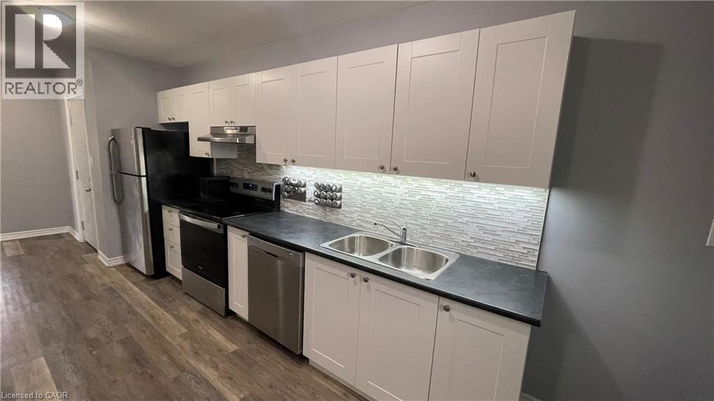 A kitchen with white cabinets and a black countertop.