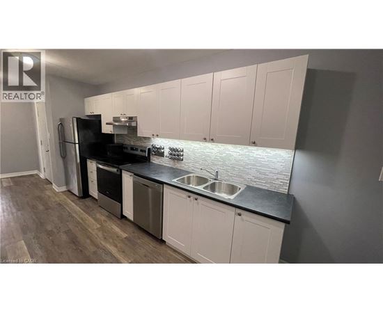 A kitchen with white cabinets and a black countertop.