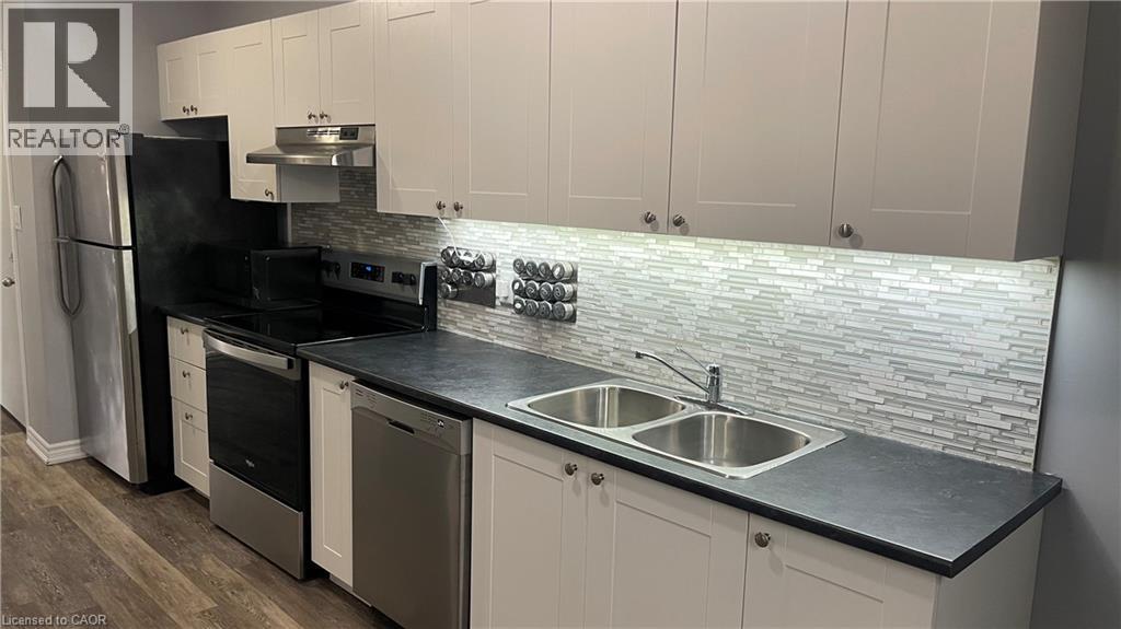 A kitchen with a black counter top and white cabinets.