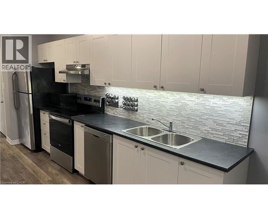 A kitchen with a black counter top and white cabinets.