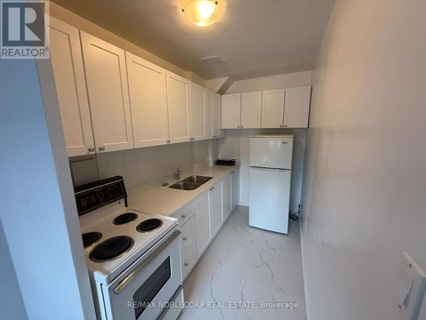 A kitchen with white cabinets and appliances.