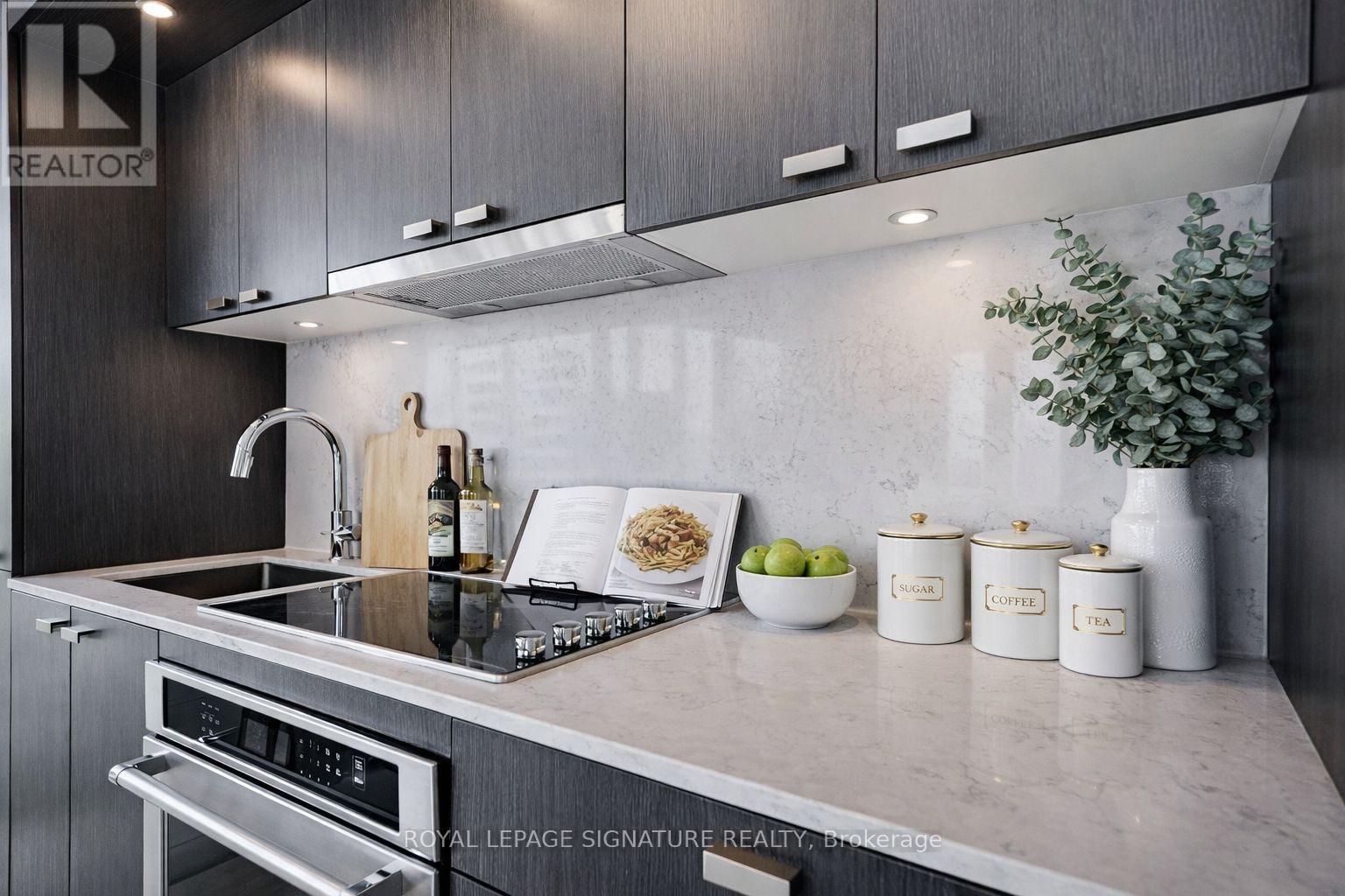 A modern kitchen with a stainless steel sink and a range hood.