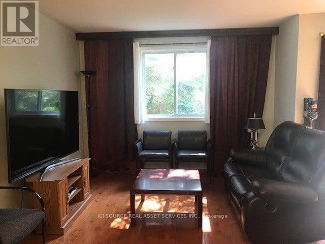 A living room with a television, two chairs, and a coffee table.