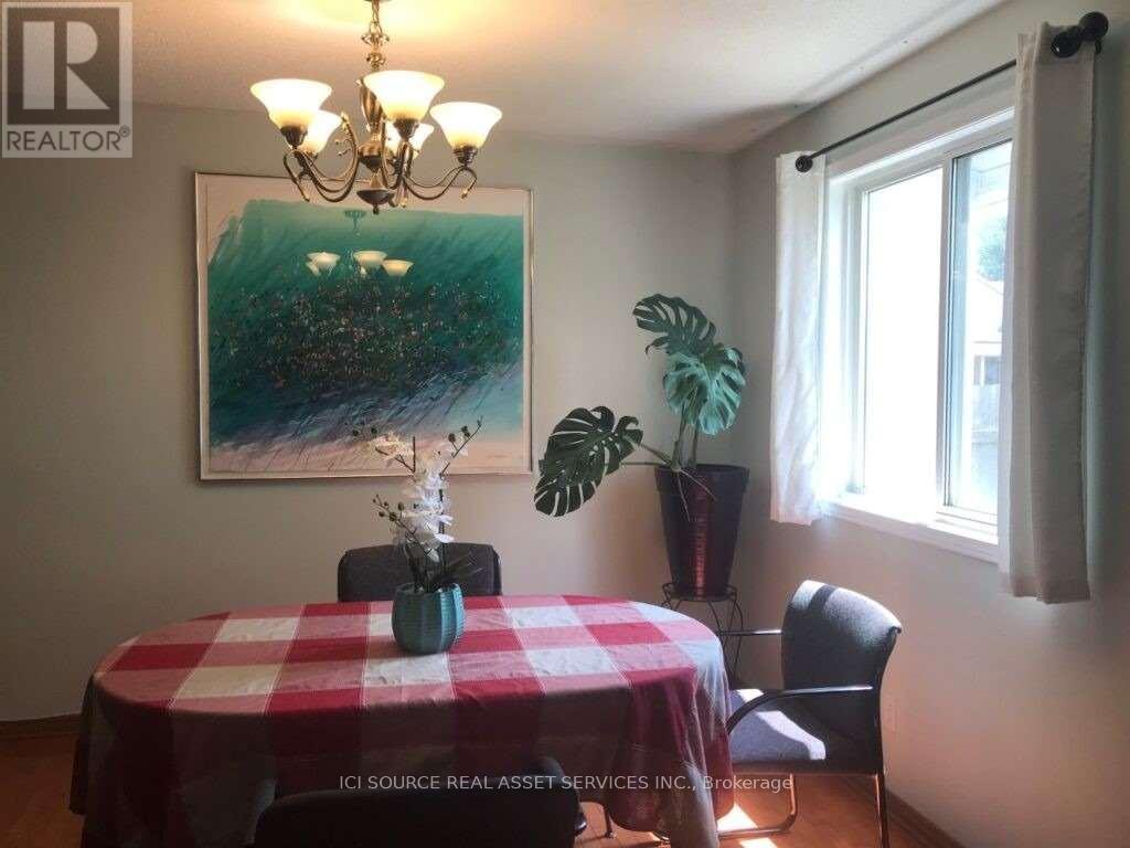 A dining room with a table and chairs.