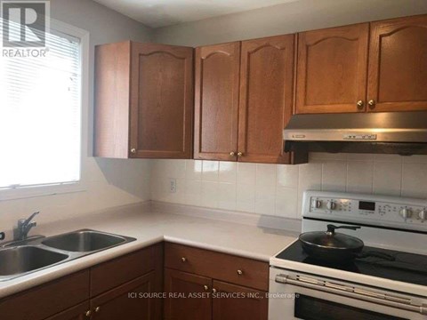 A kitchen with wooden cabinets and a stove top oven.