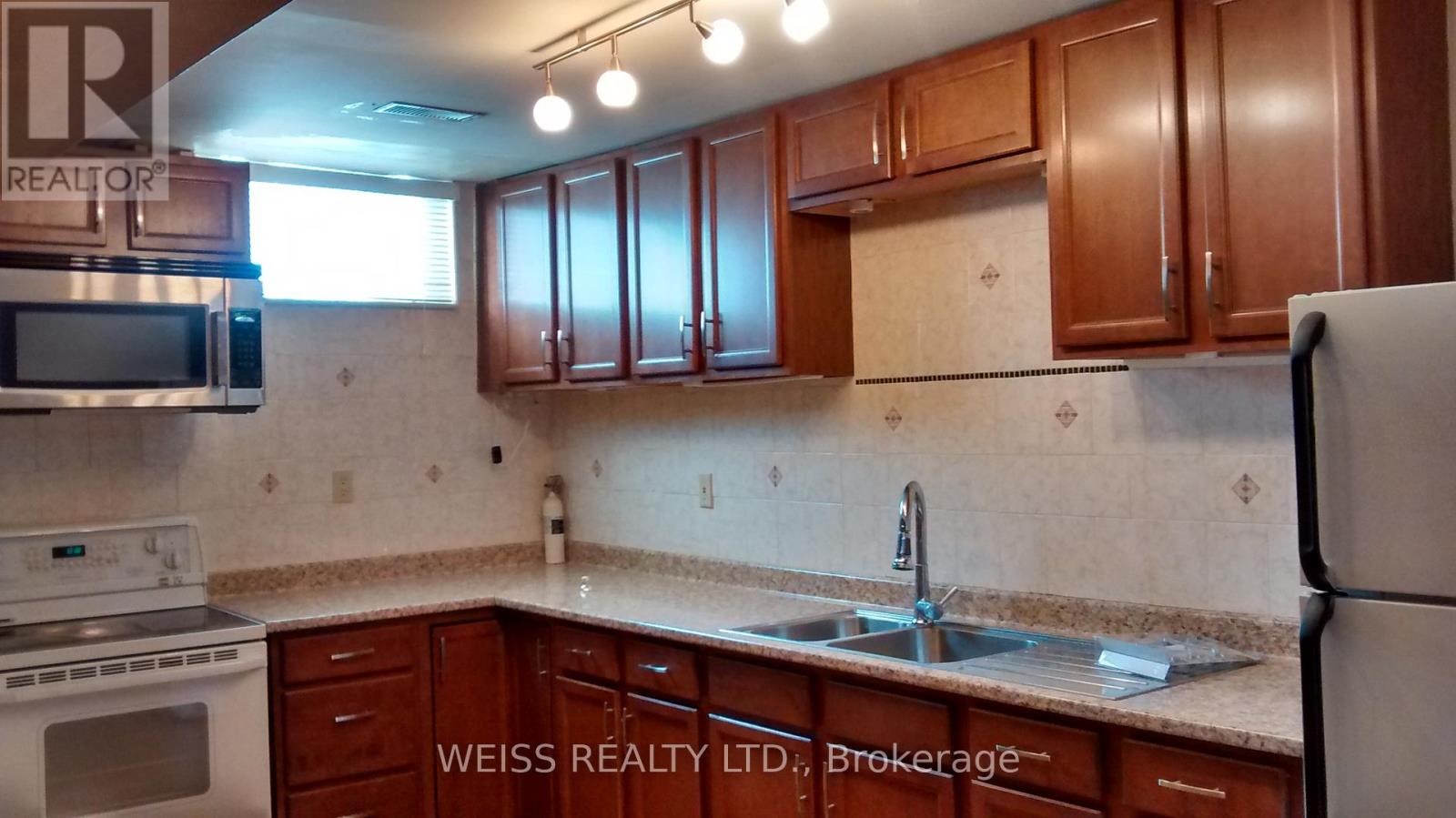 A kitchen with brown cabinets and a white refrigerator.