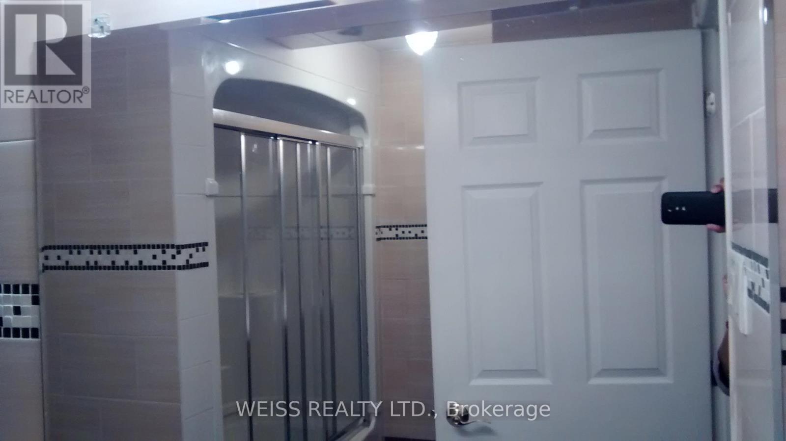 A white door is in a room with a glass shower stall.