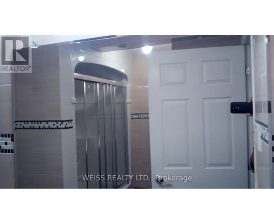 A white door is in a room with a glass shower stall.