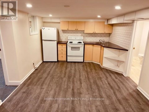A kitchen with white appliances and wooden cabinets.