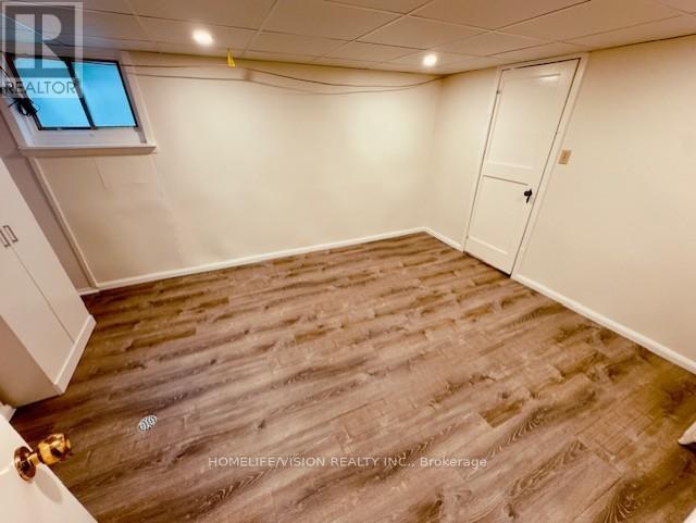 A room with wooden flooring and a white door.