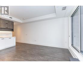 A spacious room with a wooden floor and white walls.