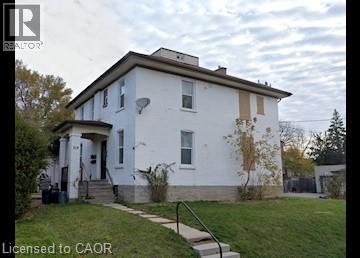 A white house with a brown roof and a small porch.