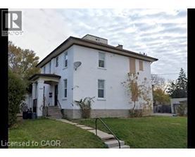 A white house with a brown roof and a small porch.