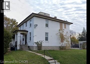 A white house with a brown roof and a small porch.
