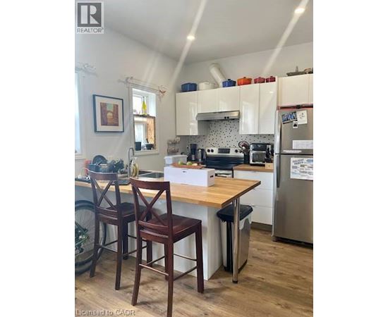 A kitchen with a wooden table and chairs.