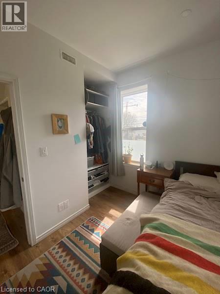 A bedroom with a bed, a rug, and a window.