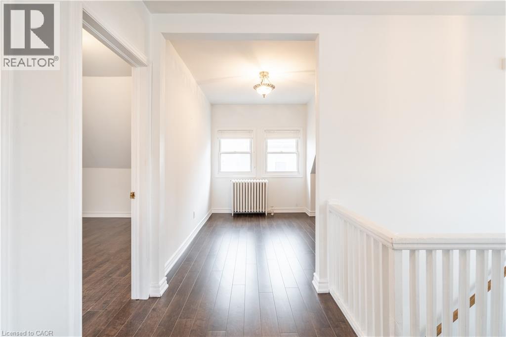 A spacious room with wooden floors and white walls.