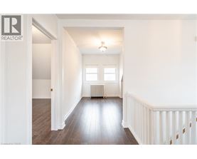 A spacious room with wooden floors and white walls.