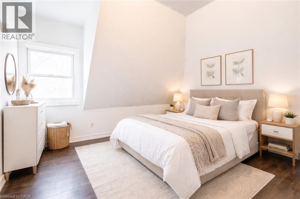 A bedroom with a large bed, a nightstand, and a dresser.