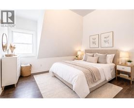A bedroom with a large bed, a nightstand, and a dresser.
