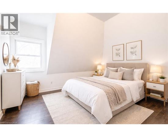 A bedroom with a large bed, a nightstand, and a dresser.