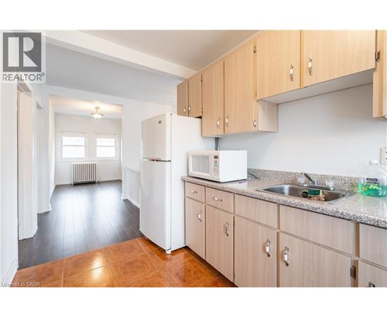 A kitchen with wooden cabinets and a white refrigerator.