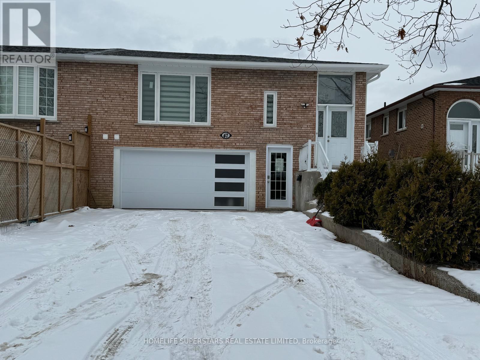 A house with a snow-covered driveway and a garage door.