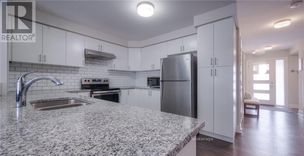 A kitchen with a granite countertop and stainless steel appliances.
