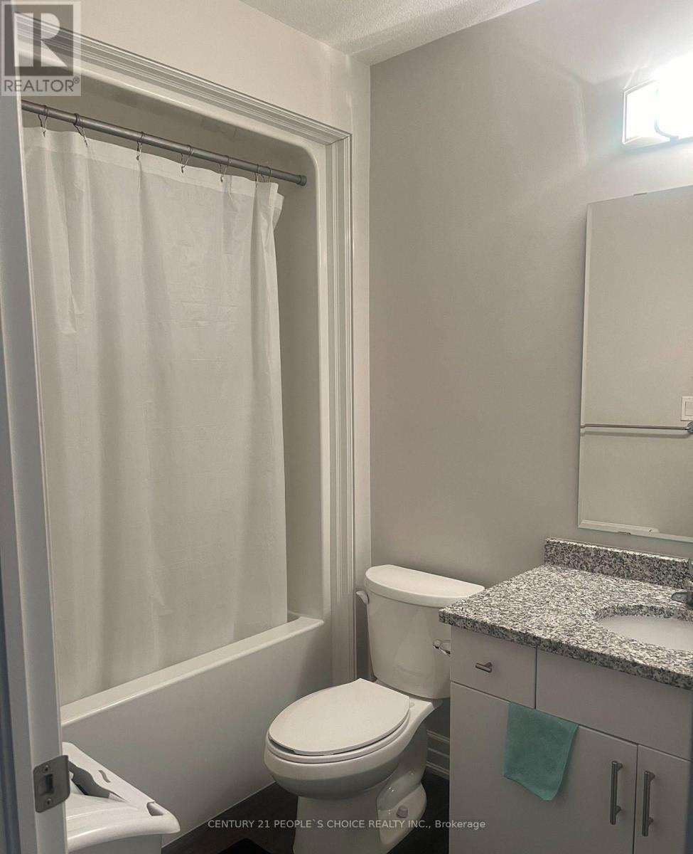 A white toilet in a bathroom with a shower curtain.
