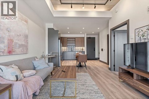 A modern living room with a grey sofa and a wooden coffee table.