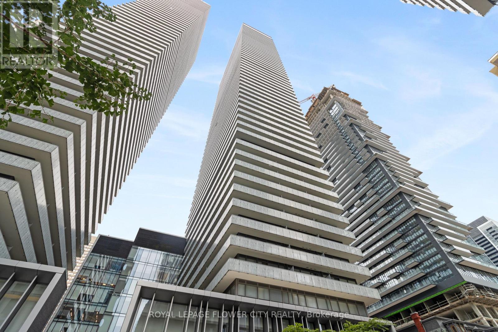 A modern building with a curved facade stands tall among other buildings.
