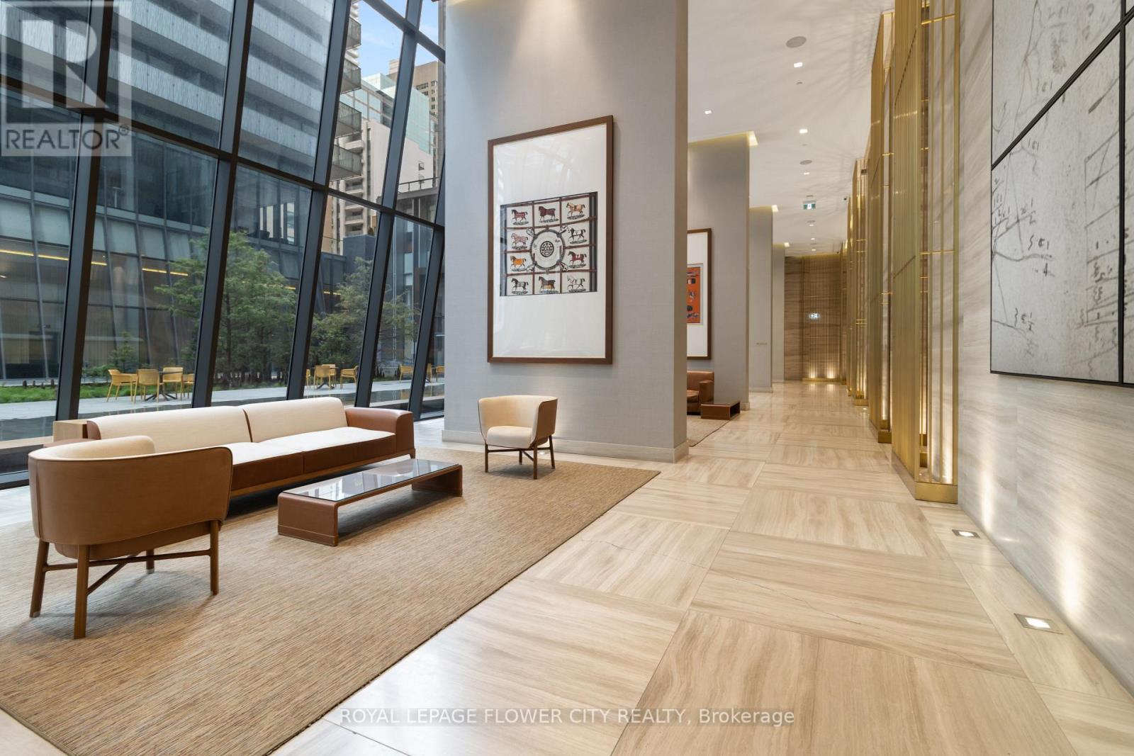 A spacious lobby with wood floors and a large painting on the wall.