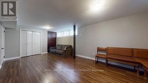 A living room with a brown couch and a wooden floor.