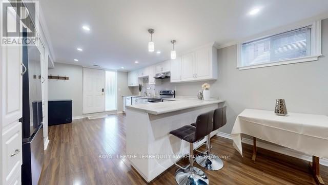 A kitchen with white cabinets and a black fridge.