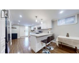 A kitchen with white cabinets and a black fridge.