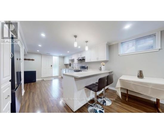 A kitchen with white cabinets and a black fridge.