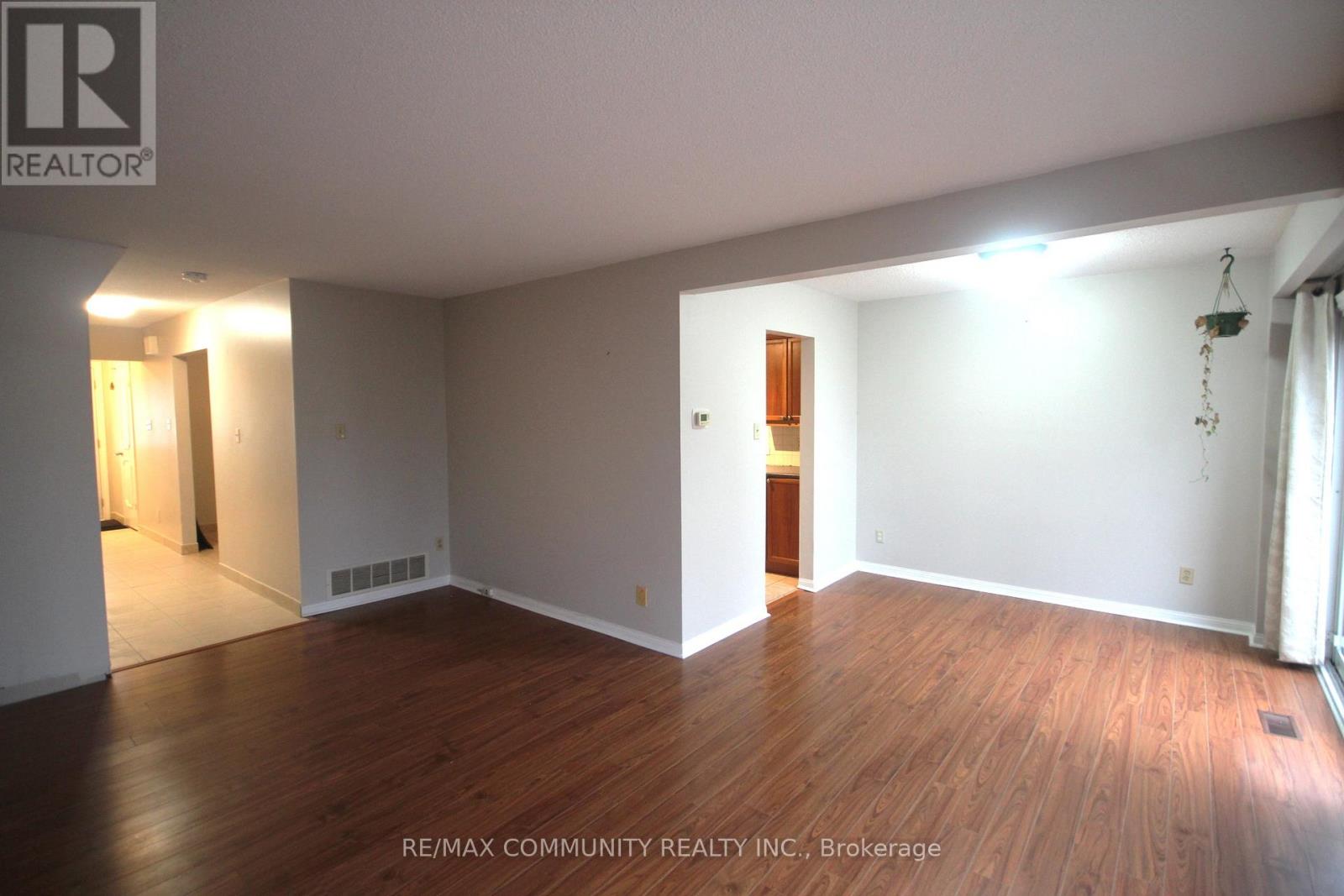 A spacious room with wooden floors and white walls.