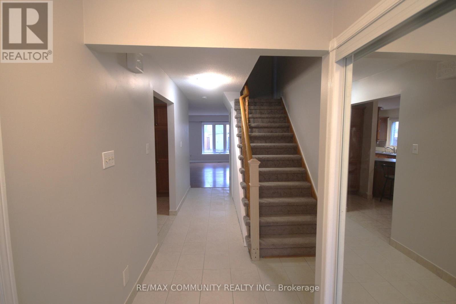 A hallway with a staircase leading to a bedroom.