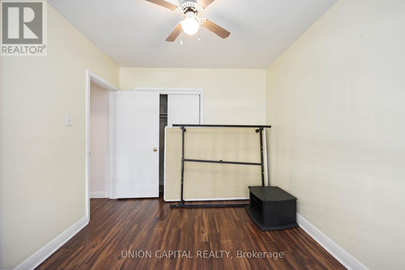 A bedroom with a bed frame and box spring in the corner.