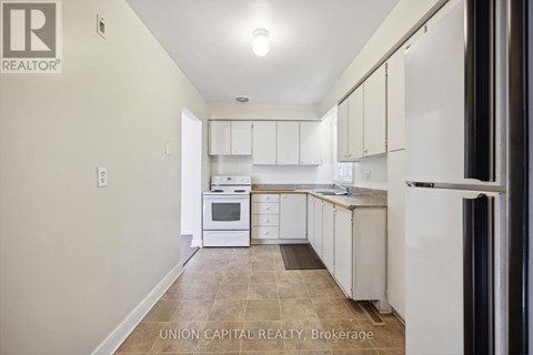 A kitchen with white cabinets and appliances in a Union Capital Realty Brokerage listing.