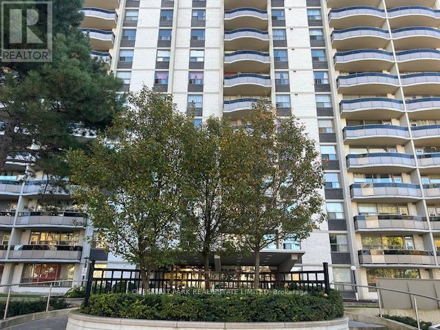 A tall residential building with a tree in front.