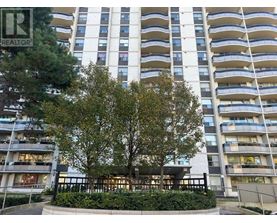 A tall residential building with a tree in front.