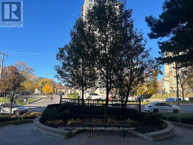A realtor sign is in front of a tree.