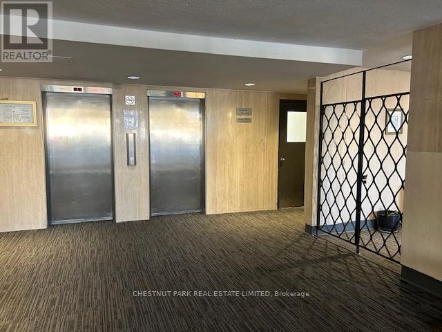 A hallway with a metal gate and wood panelled doors.