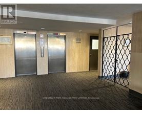 A hallway with a metal gate and wood panelled doors.