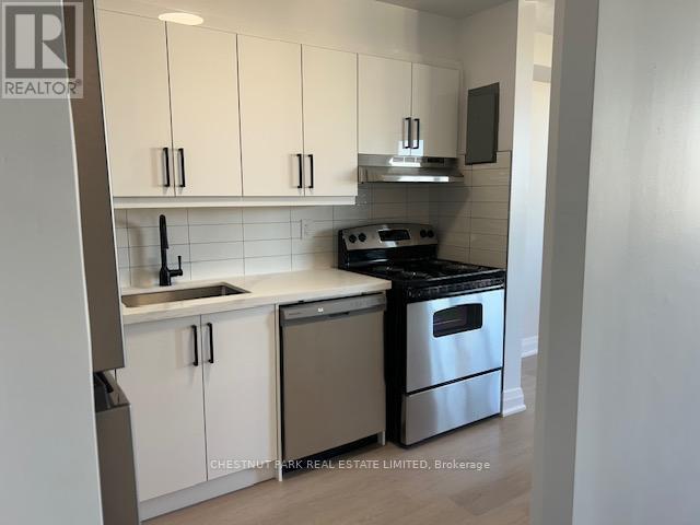 A kitchen with white cabinets and stainless steel appliances.