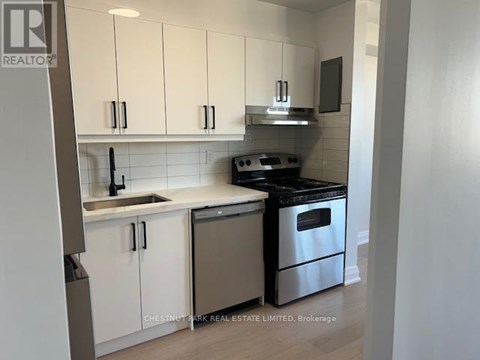 A kitchen with white cabinets and stainless steel appliances.