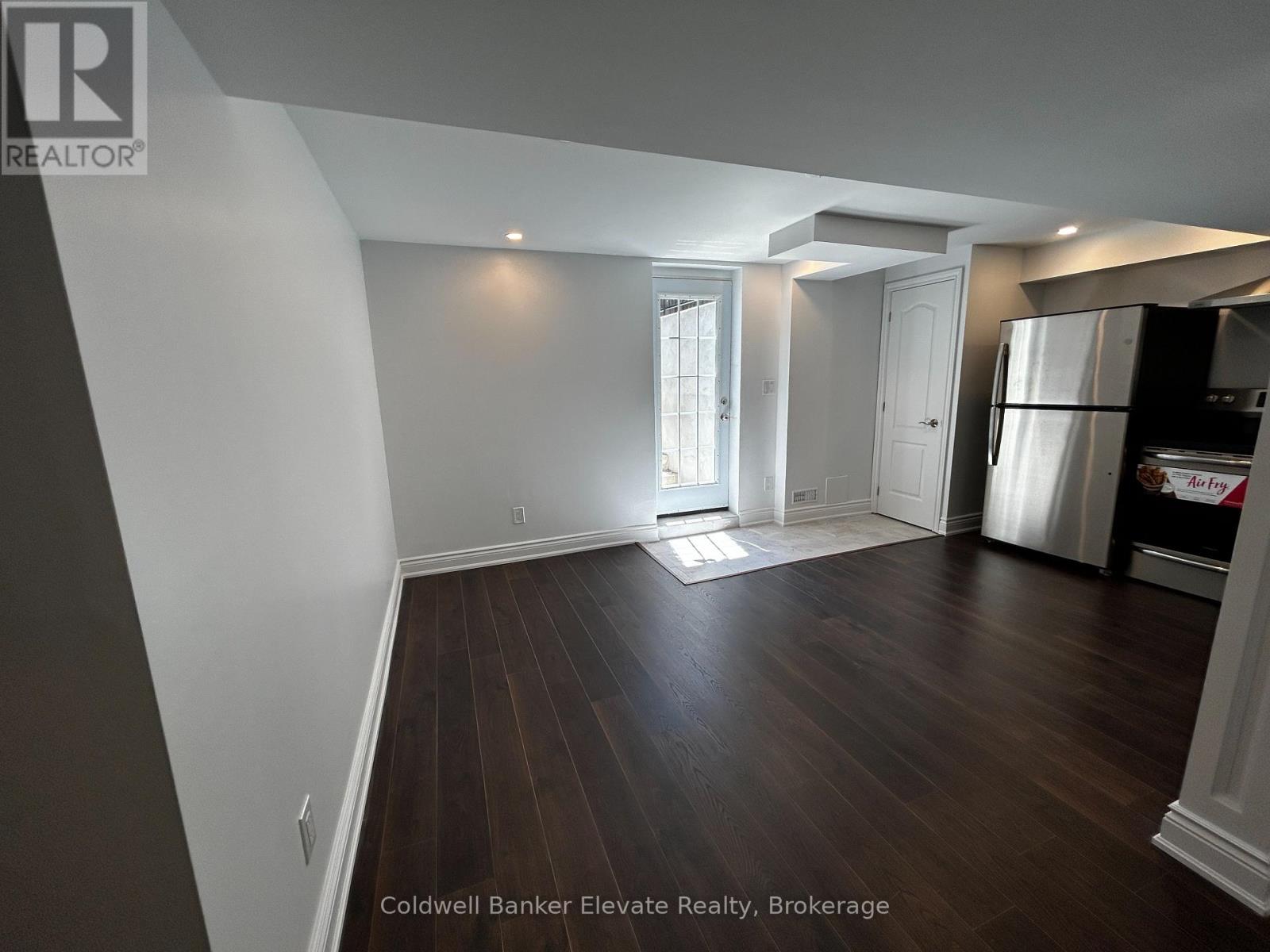 A spacious room with wooden floors and white walls.