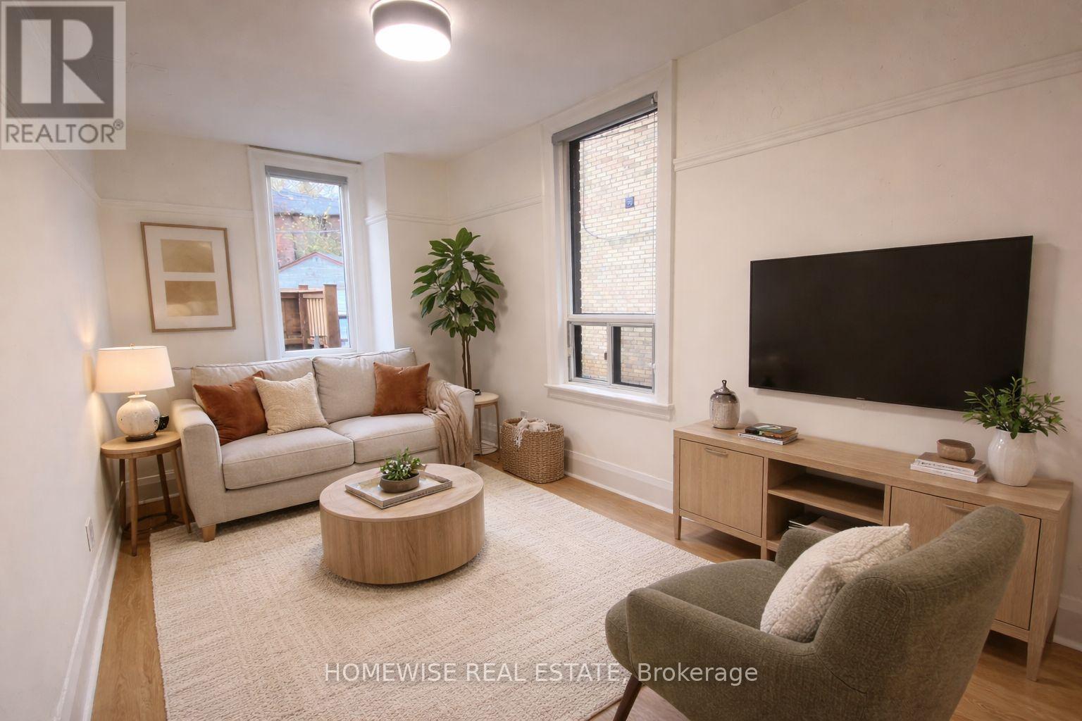 A living room with a couch, a coffee table, a television, and a plant.